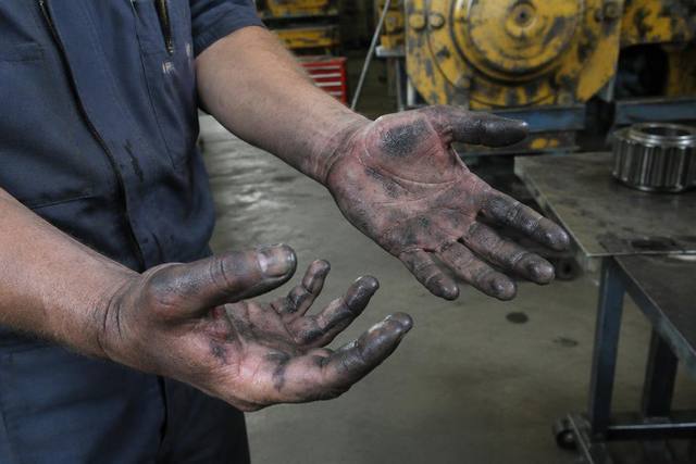 Mãos de mecânico da mineração com pele irritada por óleo e graxa