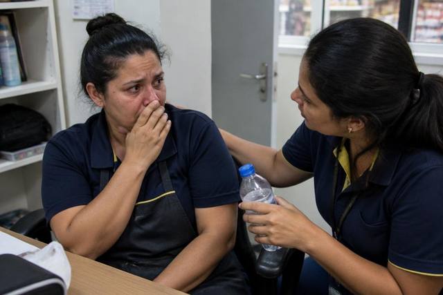 Trabalhadora recebe apoio de uma colega após sofrer um assalto no trabalho